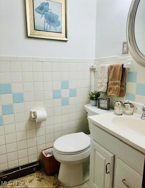 bathroom featuring tile walls, toilet, and vanity