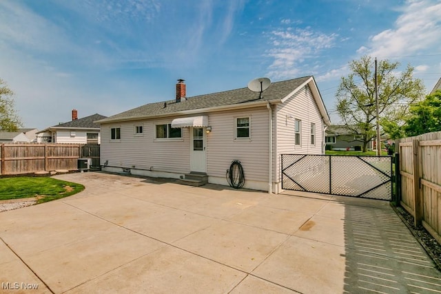 back of property featuring a patio, a chimney, entry steps, and a fenced backyard
