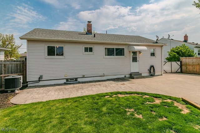 back of property with a patio, cooling unit, a chimney, fence, and entry steps