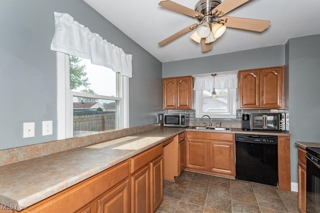 kitchen featuring brown cabinetry, stone finish flooring, ceiling fan, a sink, and black appliances