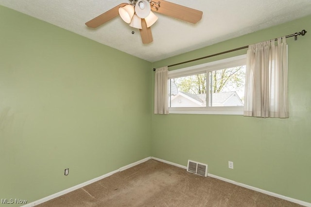 carpeted empty room featuring baseboards, ceiling fan, and visible vents