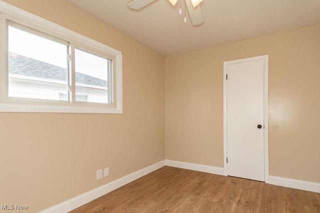 spare room featuring wood finished floors, baseboards, and a ceiling fan