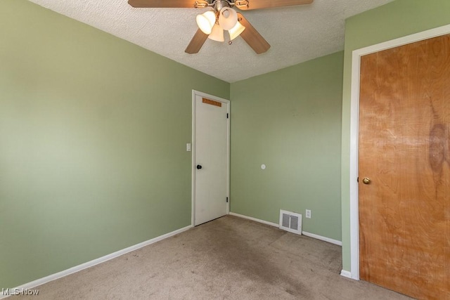 unfurnished bedroom featuring a textured ceiling, visible vents, ceiling fan, carpet floors, and baseboards