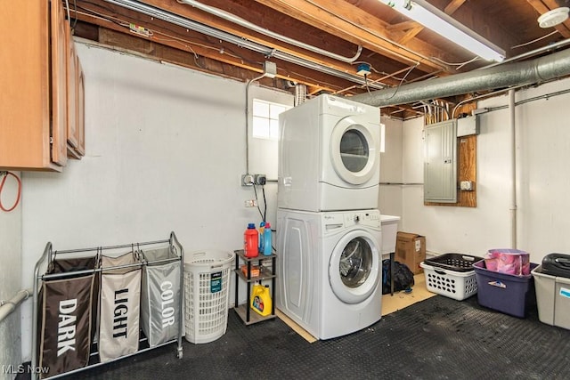laundry room with electric panel, stacked washing maching and dryer, cabinet space, and carpet flooring