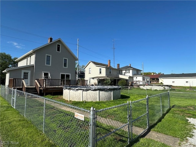 1905 Pine St SE, East Sparta, OH 44626 - rear view of property featuring a fenced backyard, a deck, a chimney, and a lawn