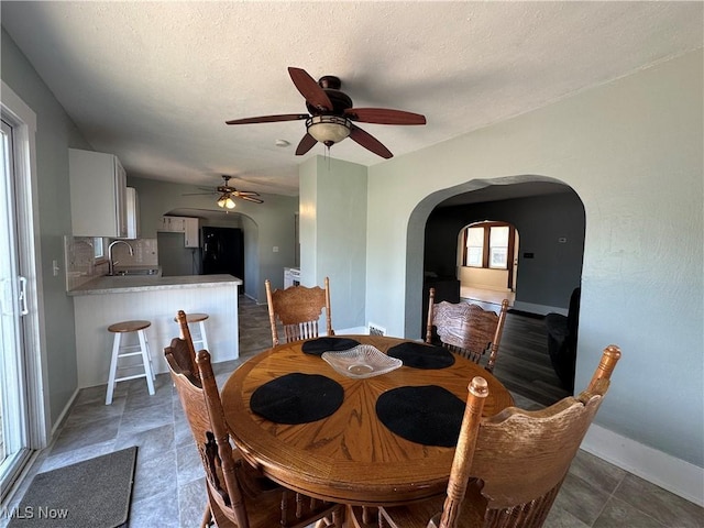 1905 Pine St SE, East Sparta, OH 44626 - dining space with arched walkways, baseboards, and ceiling fan