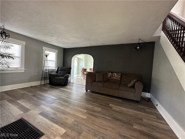 1905 Pine St SE, East Sparta, OH 44626 - living room featuring stairway, wood finished floors, baseboards, and arched walkways