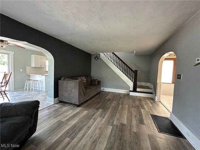 1905 Pine St SE, East Sparta, OH 44626 - living room with wood finished floors, a ceiling fan, visible vents, arched walkways, and stairs