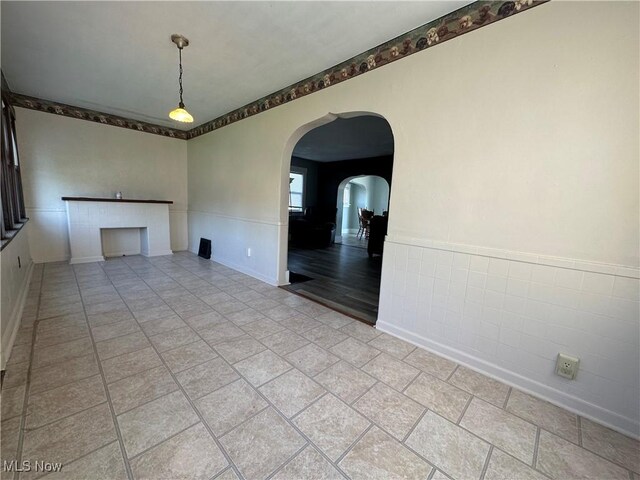 1905 Pine St SE, East Sparta, OH 44626 - unfurnished living room with arched walkways, baseboards, and a wainscoted wall