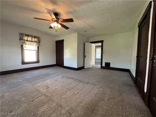 1905 Pine St SE, East Sparta, OH 44626 - spare room featuring a textured ceiling, a ceiling fan, a healthy amount of sunlight, and carpet floors