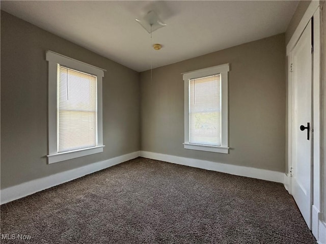 1905 Pine St SE, East Sparta, OH 44626 - spare room with baseboards and dark carpet