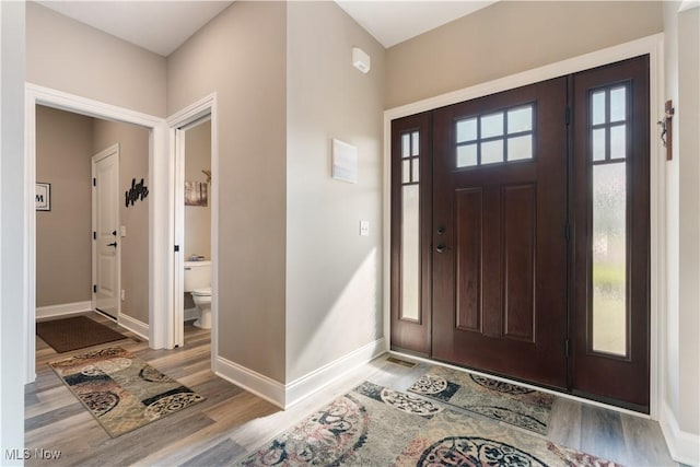 foyer entrance featuring wood finished floors and baseboards