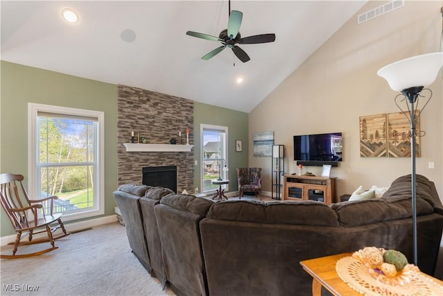 living room featuring high vaulted ceiling, a fireplace, visible vents, ceiling fan, and light carpet
