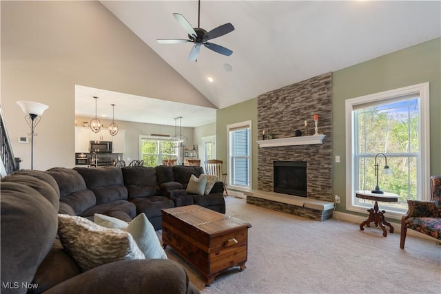 living room with a ceiling fan, high vaulted ceiling, a stone fireplace, light colored carpet, and recessed lighting