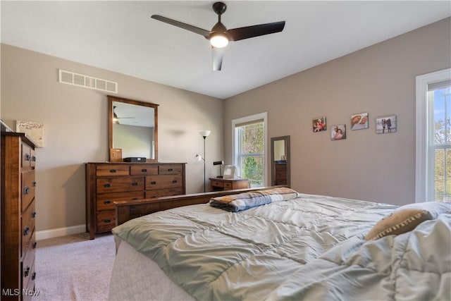 bedroom featuring baseboards, ceiling fan, light carpet, and visible vents