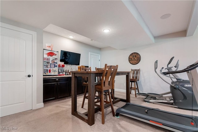 workout room featuring light carpet, recessed lighting, and bar
