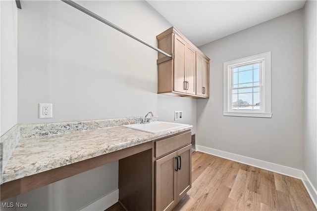clothes washing area featuring a sink, washer hookup, cabinet space, and baseboards