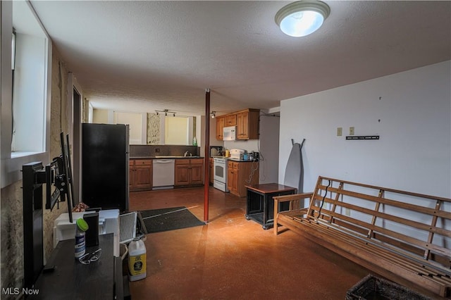 kitchen with concrete flooring, brown cabinetry, and white appliances