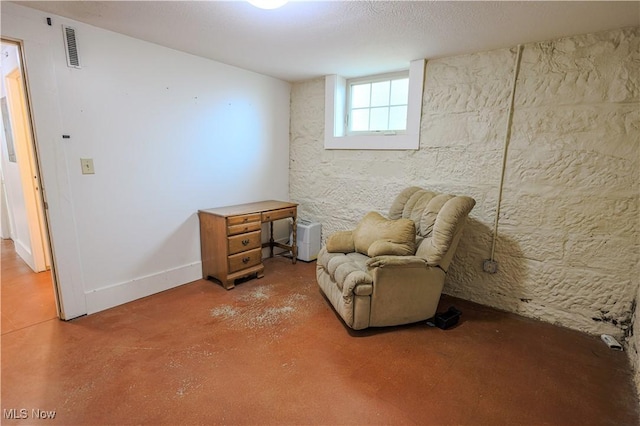 sitting room with visible vents and finished concrete flooring