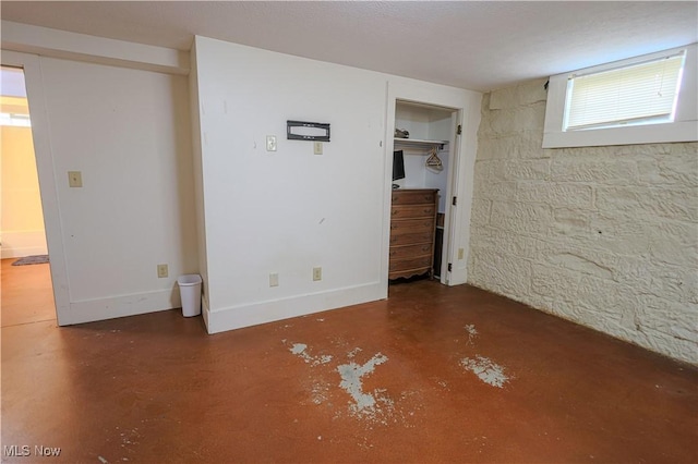 interior space featuring concrete floors and baseboards