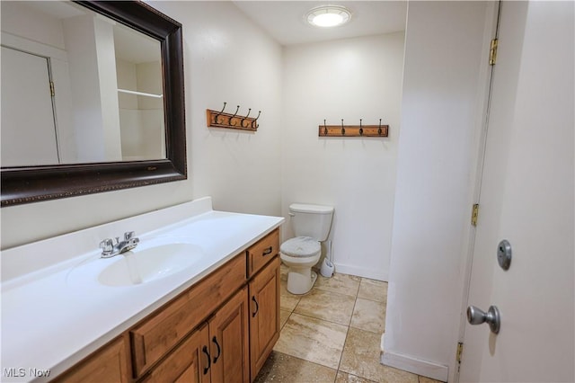 bathroom featuring vanity, toilet, and baseboards