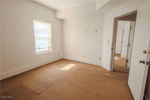 carpeted empty room with baseboards