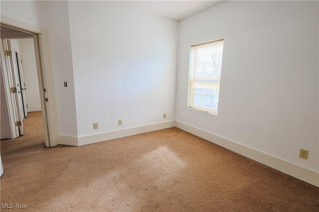 spare room featuring baseboards and carpet floors