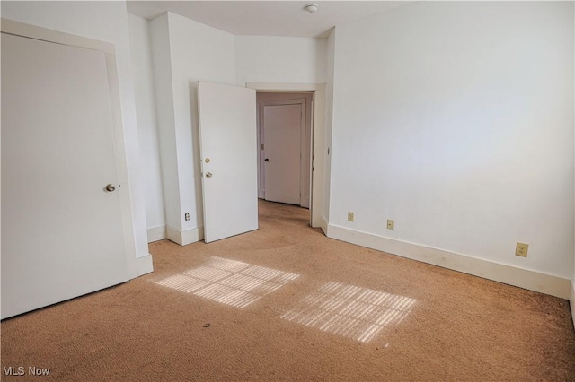 carpeted spare room featuring baseboards