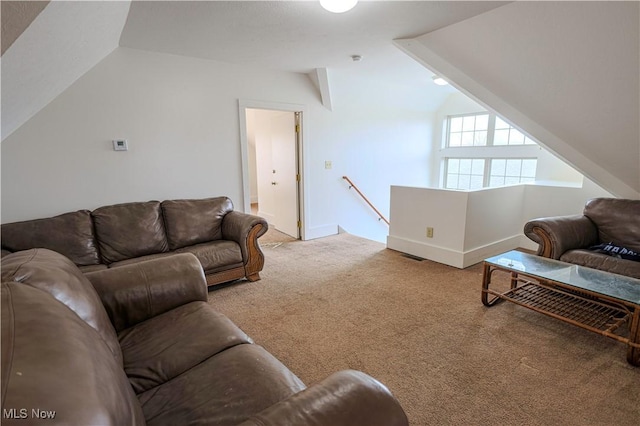 carpeted living area featuring visible vents, baseboards, and lofted ceiling