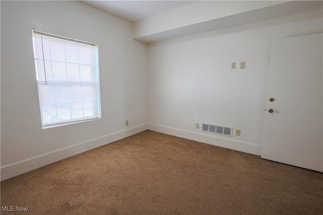empty room featuring carpet flooring, baseboards, and visible vents