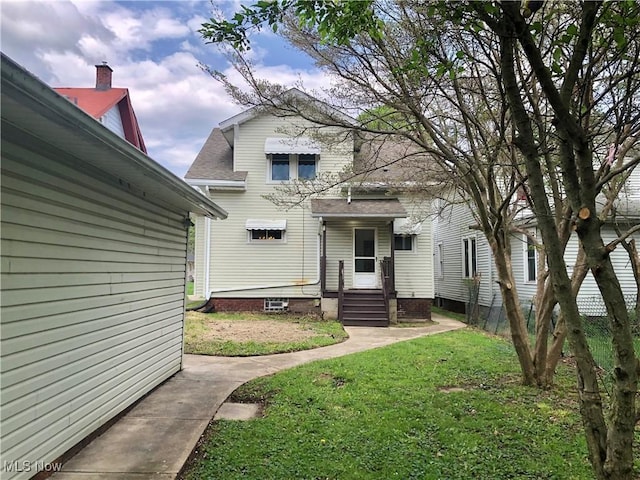 view of front facade with a front yard and a shingled roof