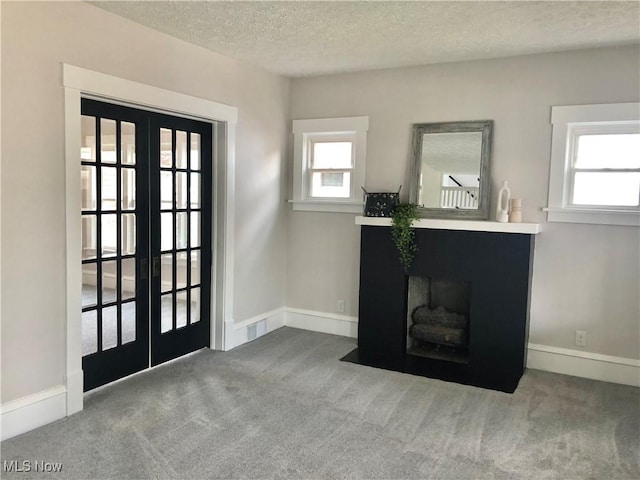 doorway to outside featuring a textured ceiling, carpet, baseboards, and french doors