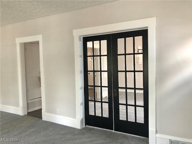 entryway featuring carpet, a textured ceiling, french doors, and baseboards