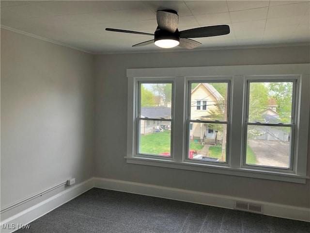 unfurnished room featuring visible vents, crown molding, dark colored carpet, a ceiling fan, and baseboards