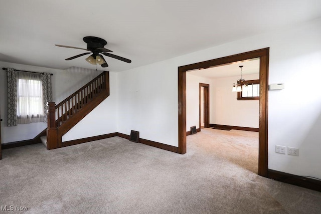 interior space with baseboards, stairs, a healthy amount of sunlight, and carpet