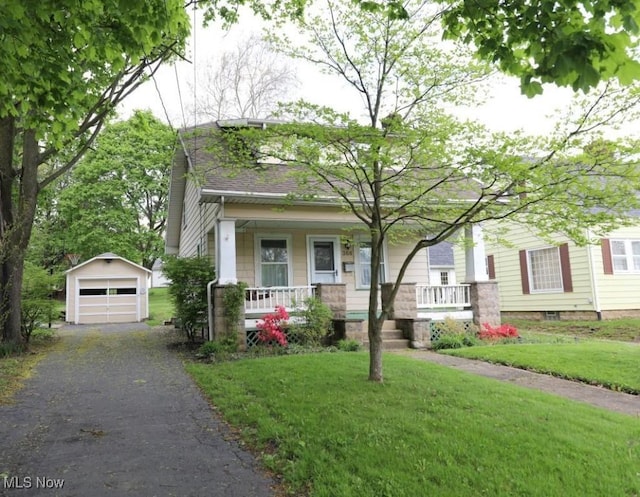 view of front of house with driveway, an outbuilding, covered porch, and a garage