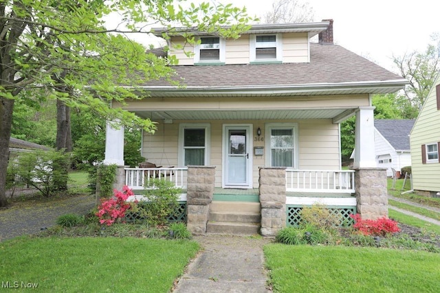view of front of home featuring covered porch, a shingled roof, and a chimney