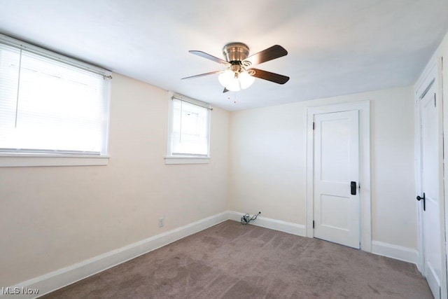 carpeted spare room with baseboards and ceiling fan