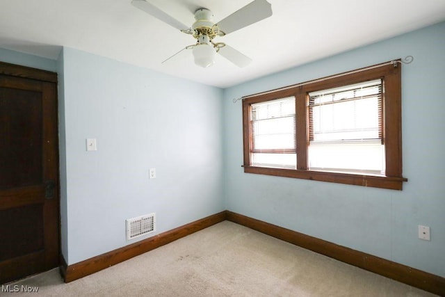 carpeted empty room featuring visible vents, baseboards, and a ceiling fan