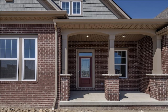 view of exterior entry featuring brick siding