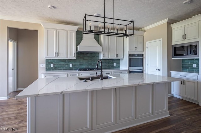 kitchen featuring dark wood-style flooring, ornamental molding, built in microwave, and a textured ceiling