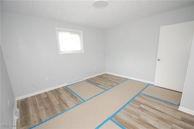 empty room with baseboards and wood finished floors