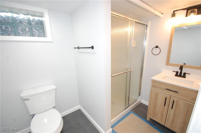 full bathroom featuring toilet, baseboards, vanity, and a shower stall