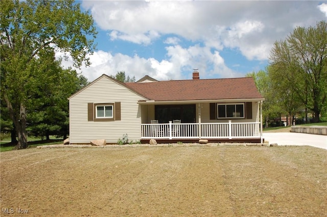 view of front of home featuring a porch and a chimney