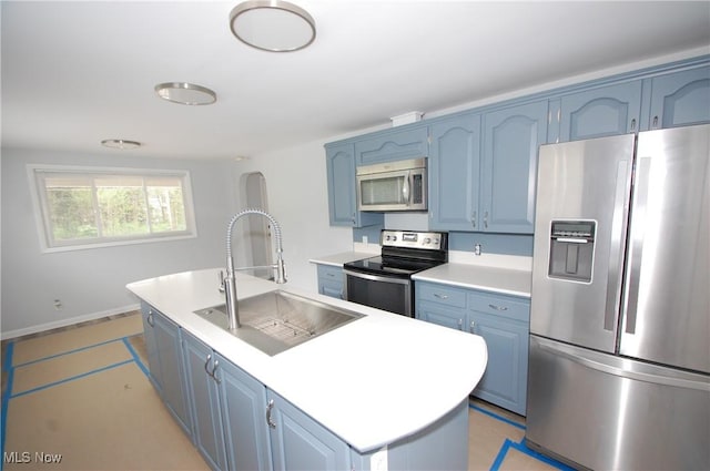 kitchen with a center island with sink, appliances with stainless steel finishes, blue cabinetry, and a sink