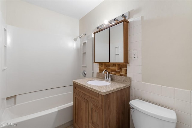 bathroom featuring vanity, toilet, decorative backsplash, and bathtub / shower combination