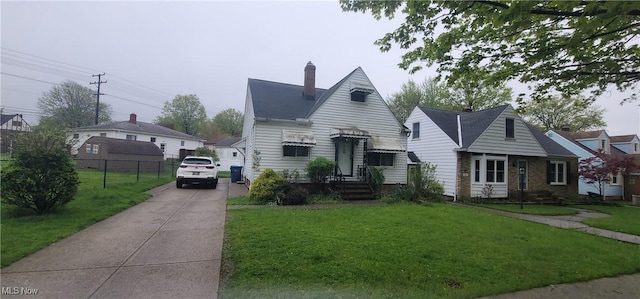 bungalow-style house with a front yard, entry steps, and fence