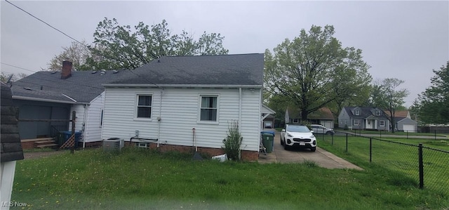 back of house featuring central air condition unit, a yard, roof with shingles, and fence