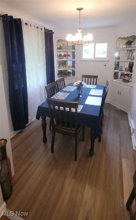 dining area with a chandelier and wood finished floors