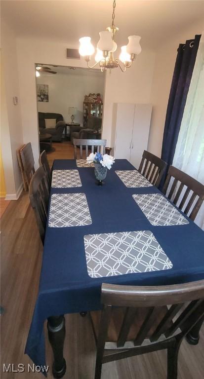 dining room featuring an inviting chandelier, visible vents, and wood finished floors